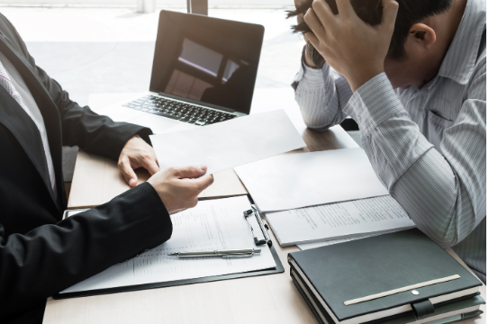 two people in business meeting with one person looking sad